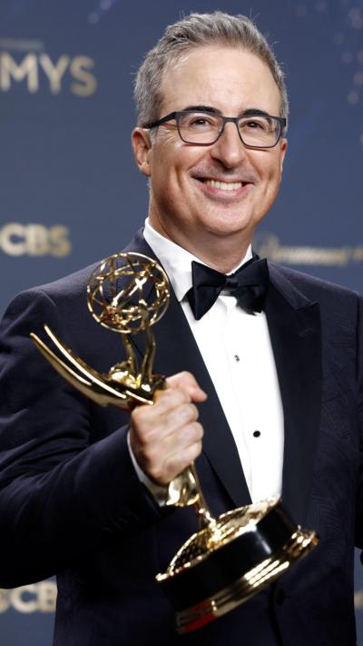 John Oliver holds an award