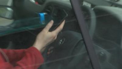 A driver filmed behind the wheel using a mobile