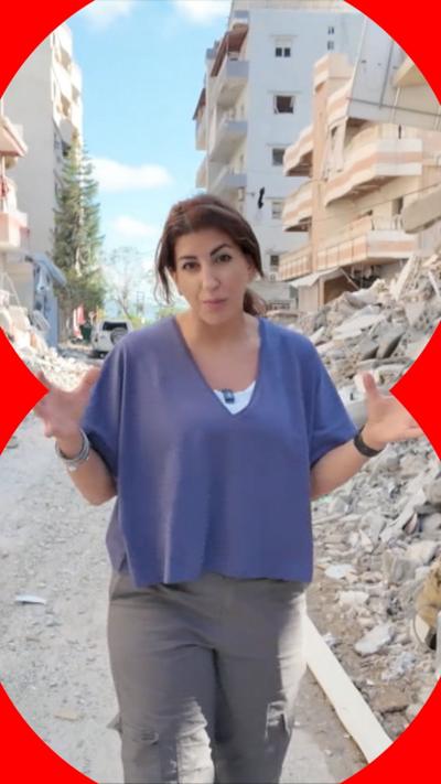 Carine Torbey speaking in Lebanon next to lots of rubble