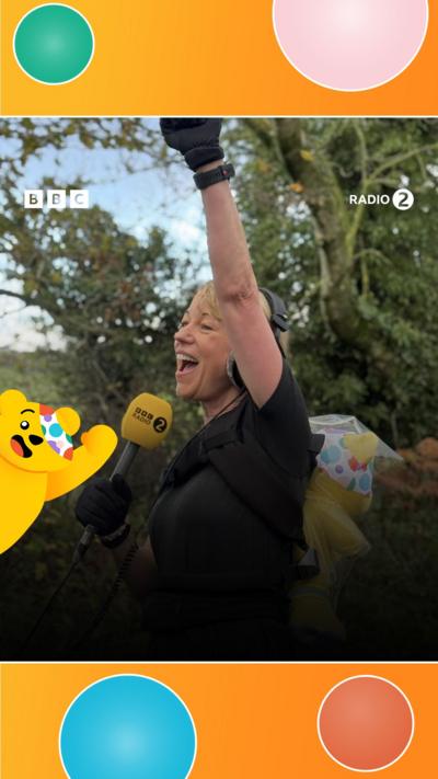 Sara Cox punches a fist in the air with joy.