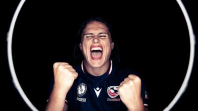 American rugby player Ilona Maher posing for her 2025 World Cup photo with her fists clenched and shouting with passion