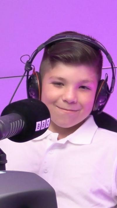 Jake sat in a while polo smiling at the camera