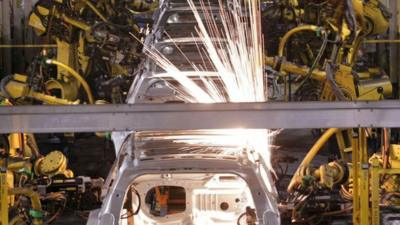 Robot arms welding cars