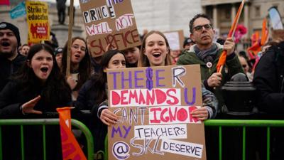 A young girl holds a banner in support of her teachers, during a strike rally in Trafalgar Square on 15 March 2023.