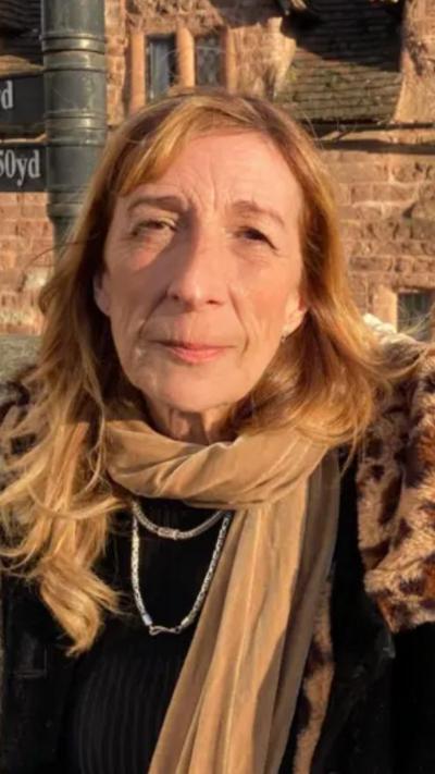 Woman with long red hair, black coat and gold scarf