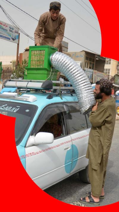 A taxi driver position an air conditioning unit on top of his vehicle.
