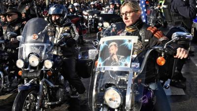 Hundreds of leather-clad bikers follow the French singer's coffin down the Champs-Elysees.