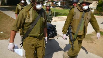 Soldiers carry a body bag