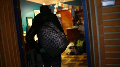 A migrant walking through a doorway