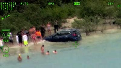 Car in water after driving on beach