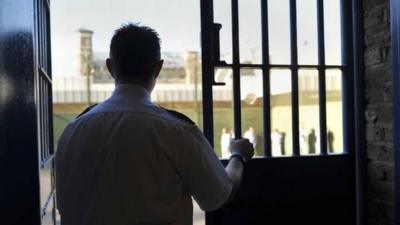 Prison Officer in front of bars