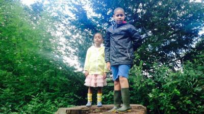 Jayden and Angel stood together on a tree stump