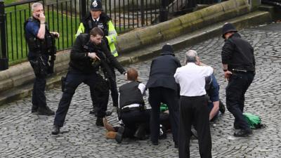 Police hold a gun to a man on the ground