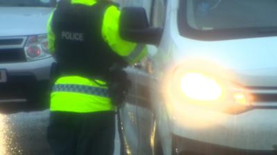 A police officer stopping a driver of a van