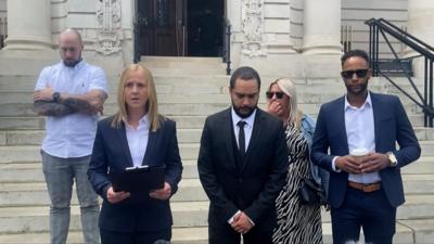 Family members, prosecutors and the police standing of the steps of Cardiff Crown Court