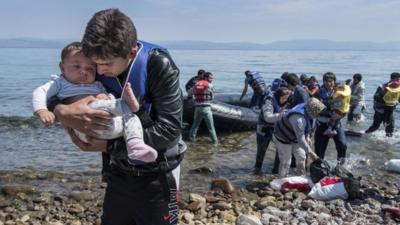 Migrants being helped from the sea in Lesbos