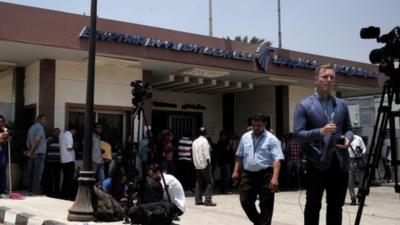 Journalists gather in front of the Egypt Air In flight services building