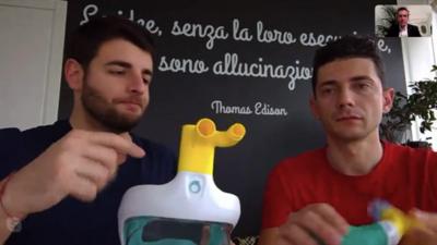 Two men show how the valve is attached to the snorkelling mask.