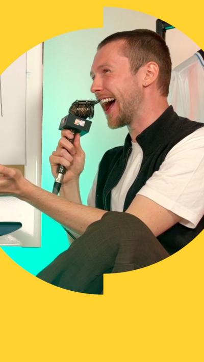Jordan Kenny speaking into a mic and laughing