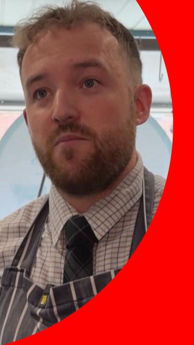 Rob Mollatt wears a dark tie and apron with short blonde hair