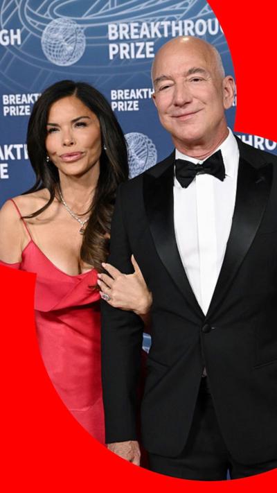 Sanchez and Bezos posing for a photograph, both are smiling and she has her arm entangled in his