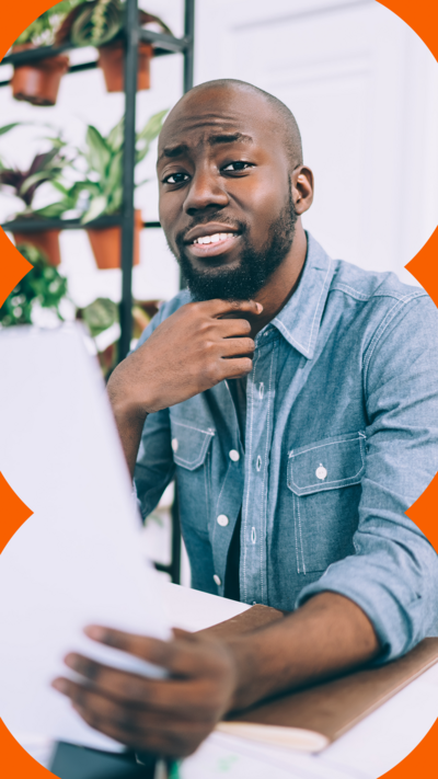 Man looking thoughtful whilst holding a piece of paper