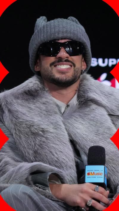 Singer Bad Bunny wearing black sunglasses, grey fur coat and hat 