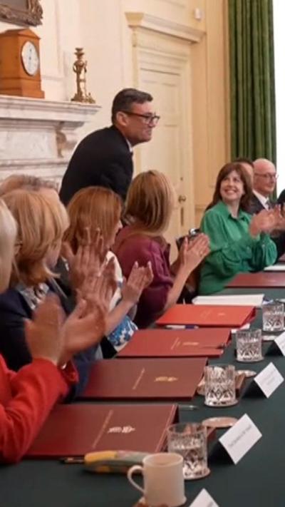 Andy Burham stood next to his cabinet at a table