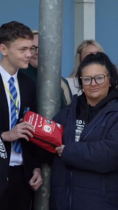 Caroline Willgoose holding up a red bleed kit
