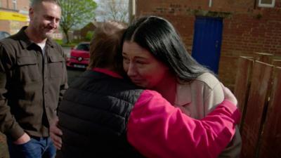 Stephanie being hugged and welcomed by one resident after being shunned 16 years ago.