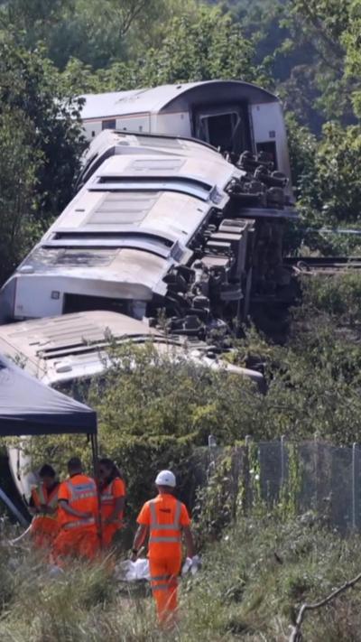 Investigators at scene, with train in background