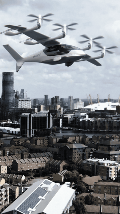 A picture of the London skyline, with the new aircraft flying above. It resembles a small plane with two small propellers along each wing.