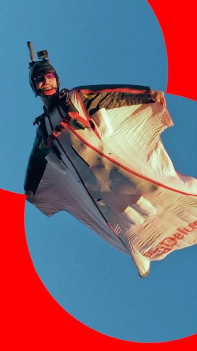 A man in a wingsuit and a black helmet