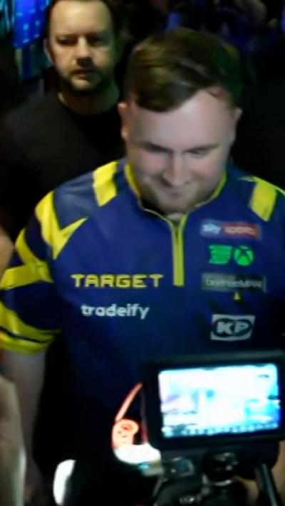 a man in a blue and yellow shirt walking through a pub