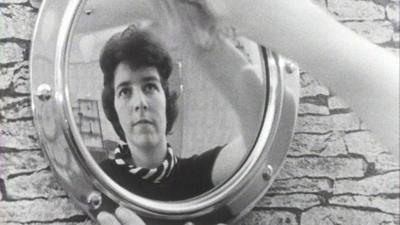 A woman polishing a mirror.