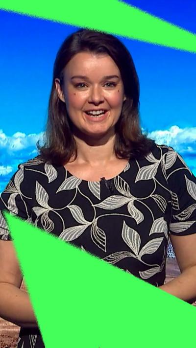 Gillian Smart has shoulder-length brown hair, wears a black top with white leaves pattern