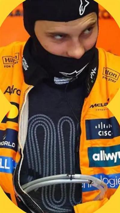 Driver Oscar Piastri wears a black cooling vest under an orange jacket 