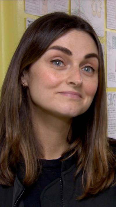 a woman with long brown hair raising her eyebrows