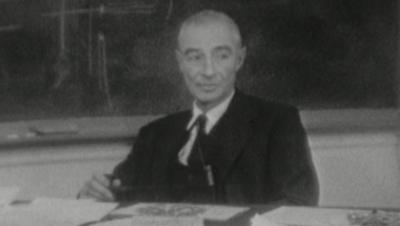 Robert Oppenheimer sitting at a desk.