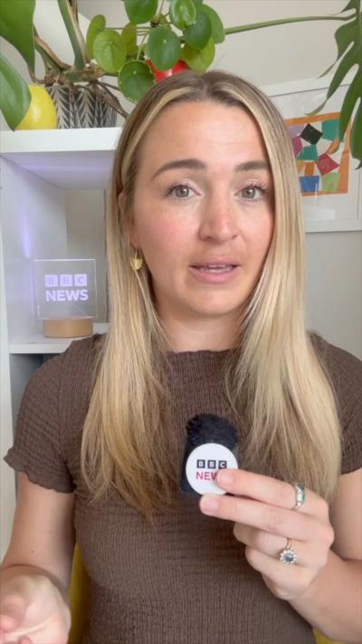 A woman with long blonde hair talks to the camera