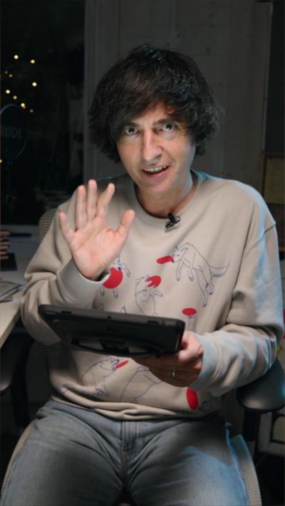 Uncanny podcast presenter Danny Robins reading from an iPad and looking at the camera