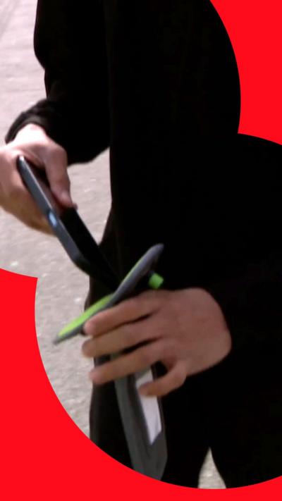 A pupil putting a phone into a lockable wallet.
