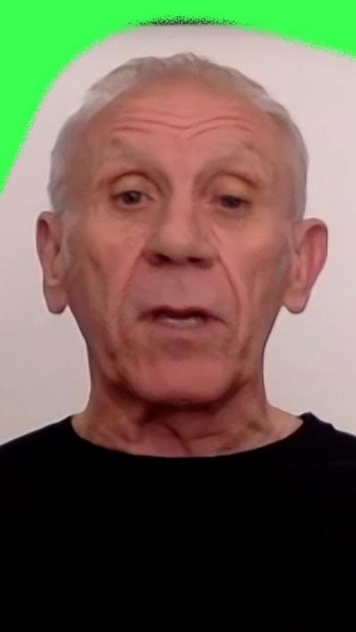 Former England midfielder Peter Reid. He is wearing a black shirt.