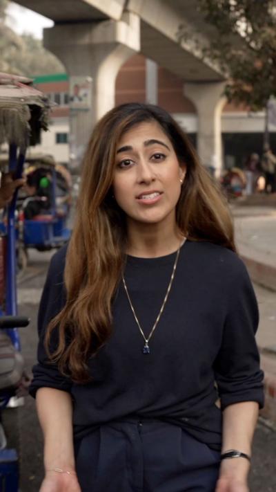 BBC correspondent Azadeh Moshiri standing in front of motor bikes on a street in Dhaka