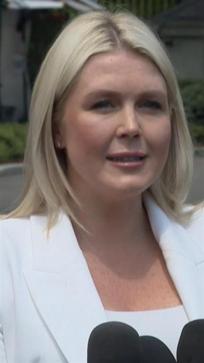 Karoline Leavitt wears a white blazer and shirt as she addresses reporters outside the White House.