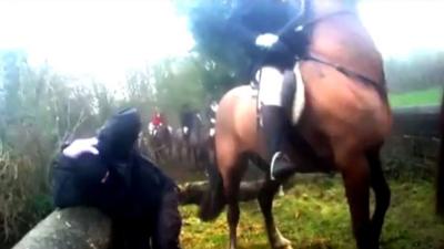 Person holds head near rider on a horse