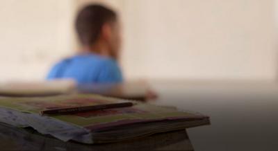 young man blurred in silhouette behind a table