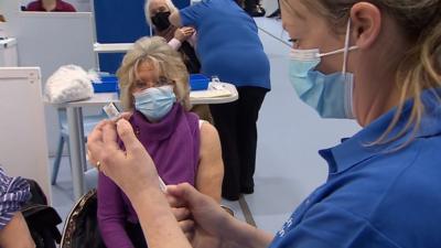 A nurse preparing to vaccinate a woman