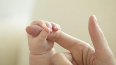 Baby holding mother's finger