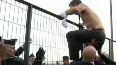 A shirtless Air France boss jumps over a fence